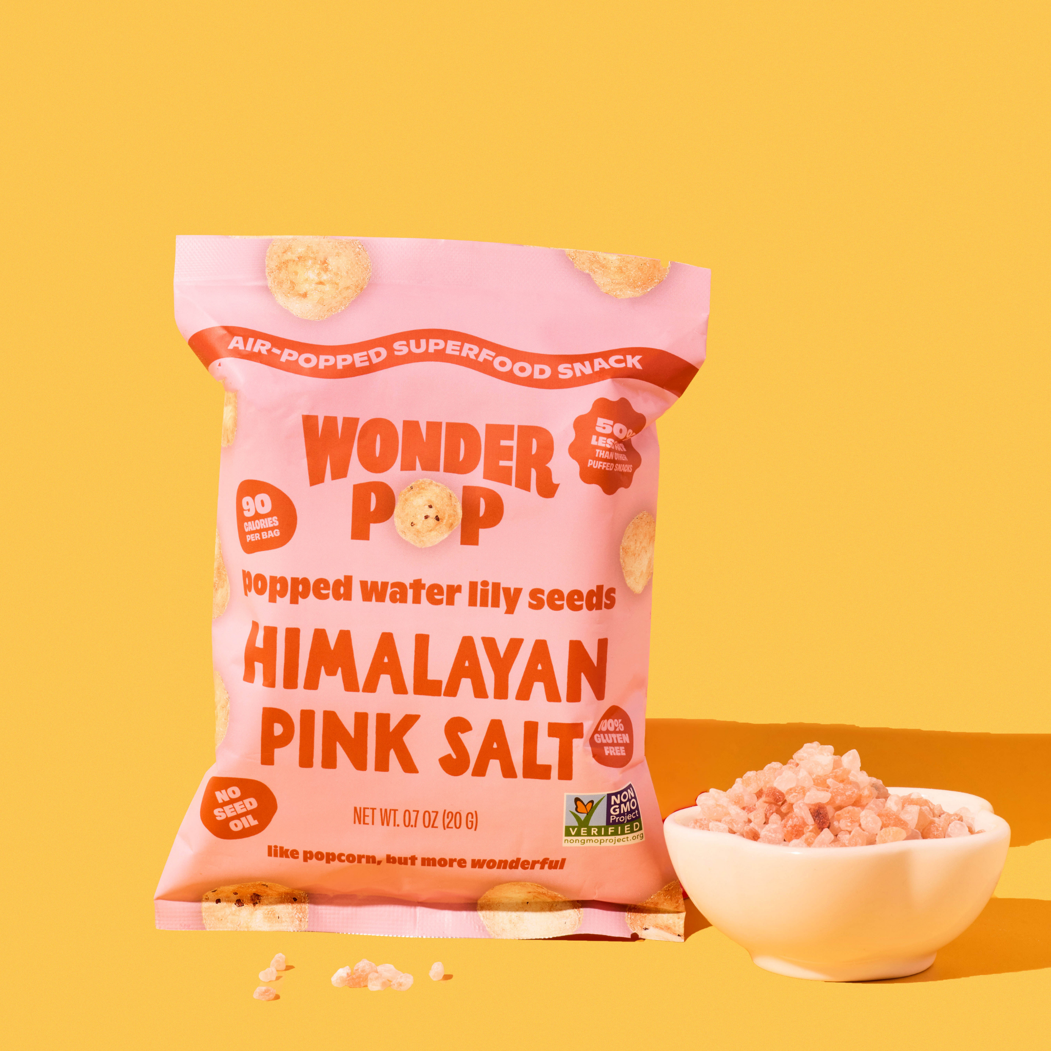 Pink package of Wonder Pop Himalayan Pink Salt popcorn on a yellow background